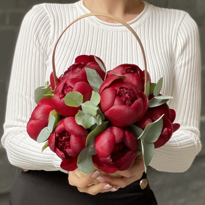 11 бордовых пионов с эвкалиптом в корзине