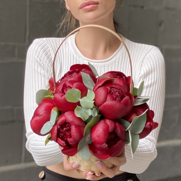 11 бордовых пионов с эвкалиптом в корзине