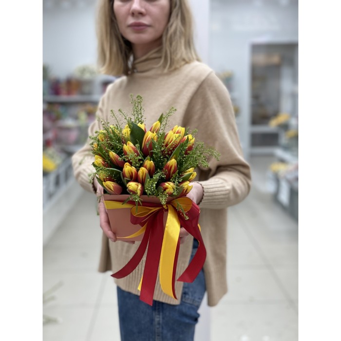 Красно-жёлтые тюльпаны в коробке с зеленью