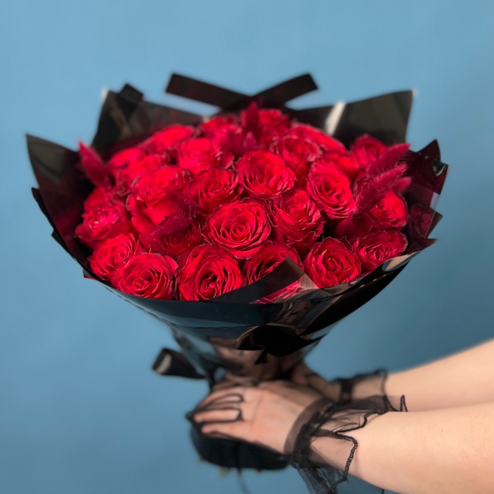 Траурный букет из 30 красных роз в черной упаковке