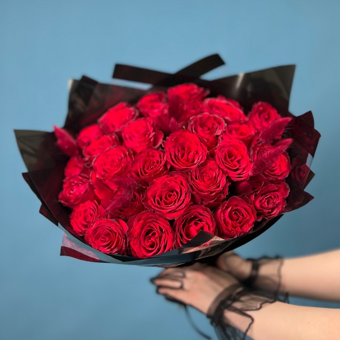 Траурный букет из 30 красных роз в черной упаковке