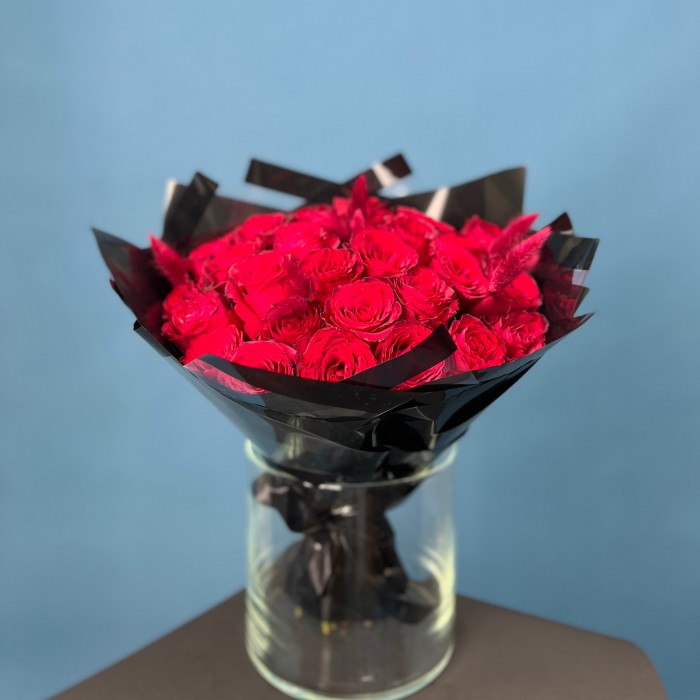 Траурный букет из 30 красных роз в черной упаковке