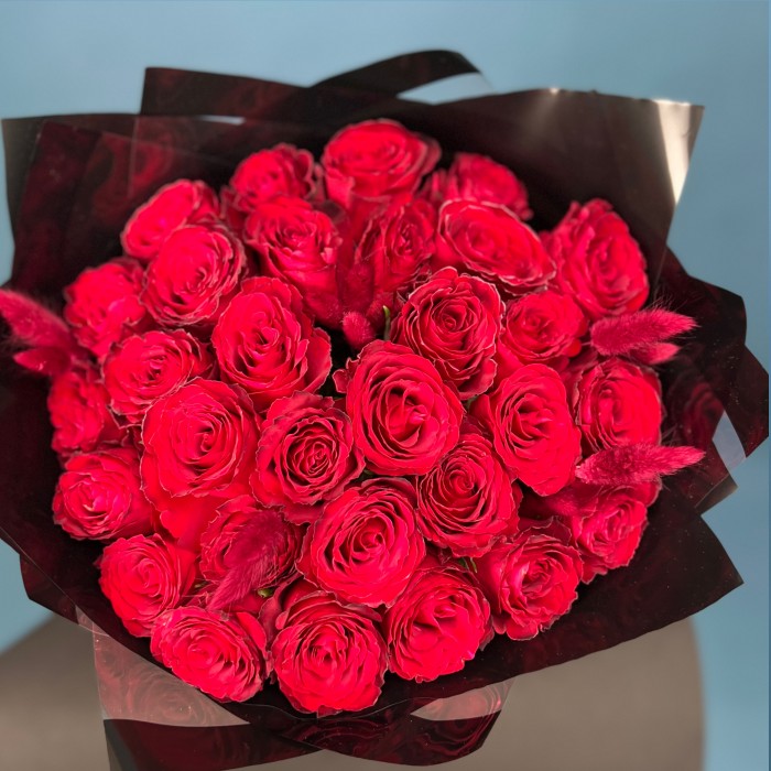 Траурный букет из 30 красных роз в черной упаковке