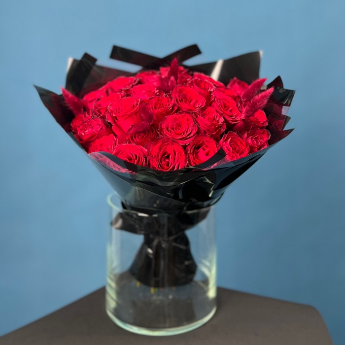Траурный букет из 30 красных роз в черной упаковке