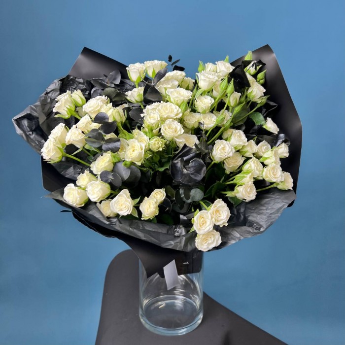 Траурный букет из 20 белых кустовых роз в черной упаковке