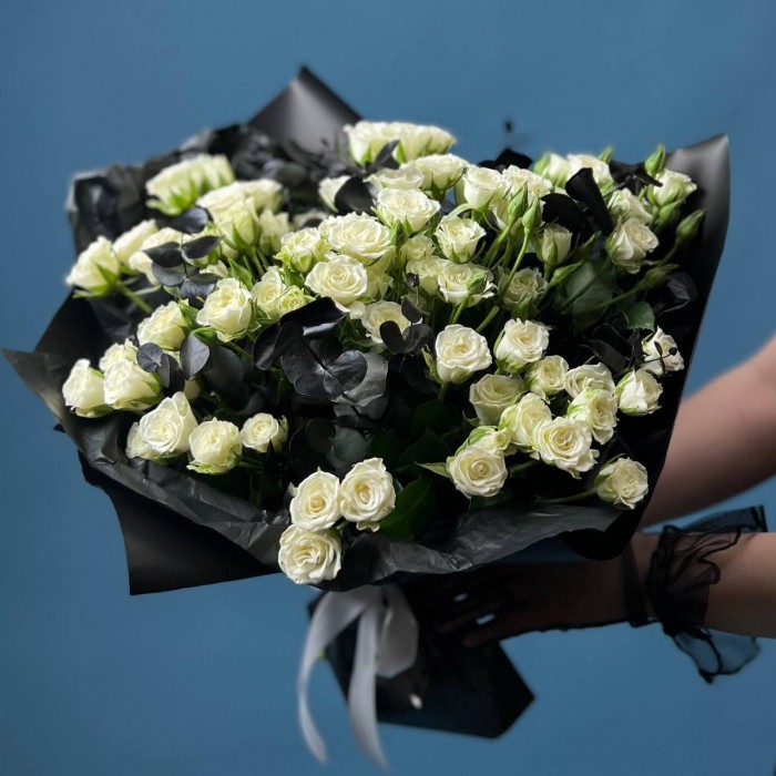 Траурный букет из 20 белых кустовых роз в черной упаковке