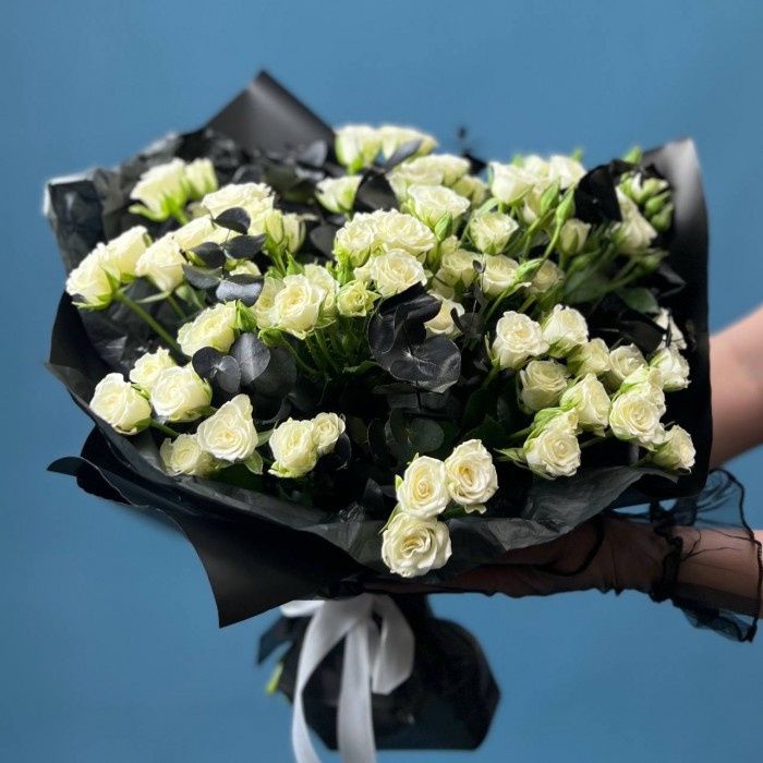 Траурный букет из 20 белых кустовых роз в черной упаковке