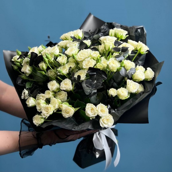 Траурный букет из 20 белых кустовых роз в черной упаковке