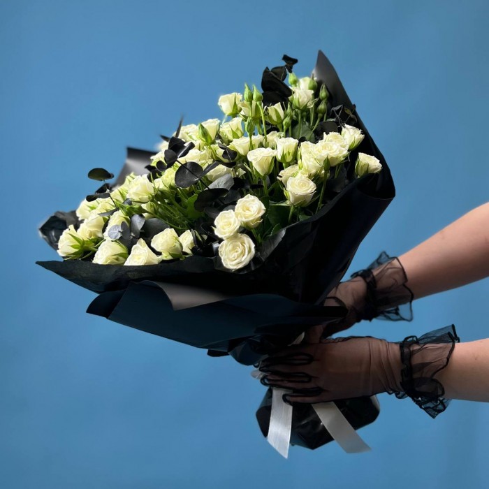 Траурный букет из 20 белых кустовых роз в черной упаковке