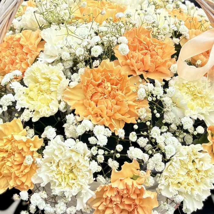 25 персиковых и белых гвоздик в корзине