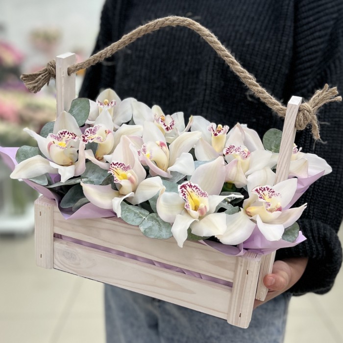 11 белых орхидей в деревянном ящике