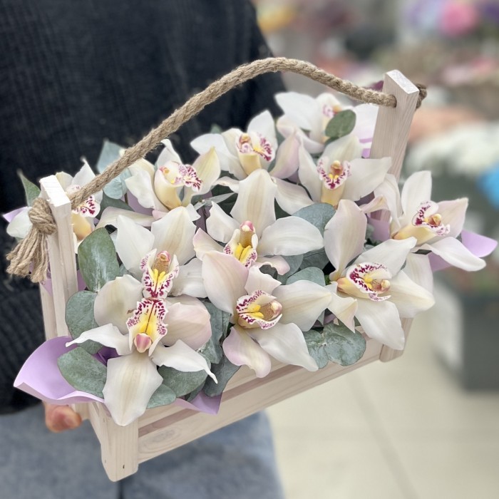 11 белых орхидей в деревянном ящике