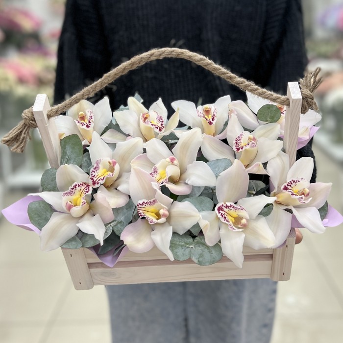 11 белых орхидей в деревянном ящике