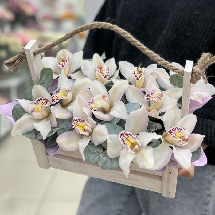 11 белых орхидей в деревянном ящике