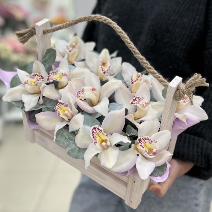 11 белых орхидей в деревянном ящике