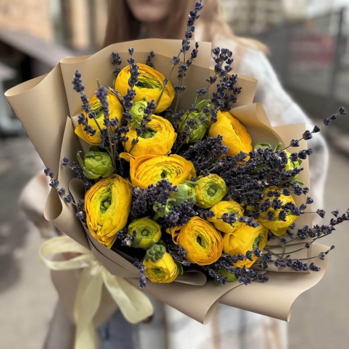 9 желтых ранункулюсов с лавандой в упаковке