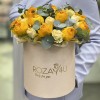 Яркие желтые ранункулюсы в коробке с розами
