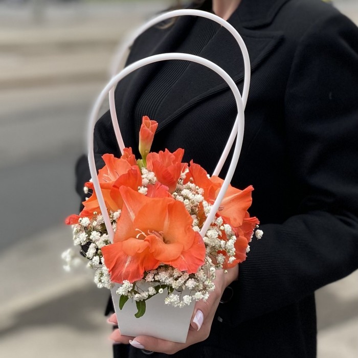Композиция с коралловым гладиолусом и гипсофилой в сумочке