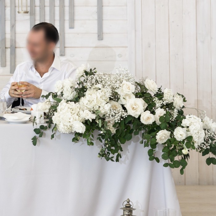 Композиция из белых гортензий и роз на стол молодоженов