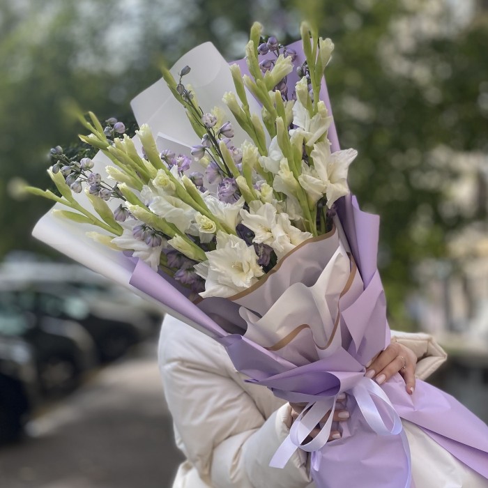 11 белых гладиолусов с дельфиниумом