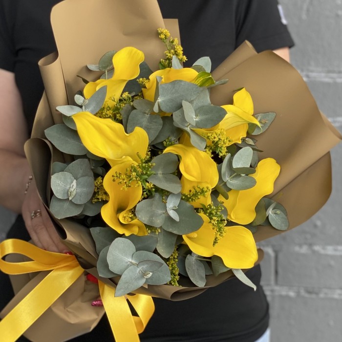 9 желтых калл с эвкалиптом