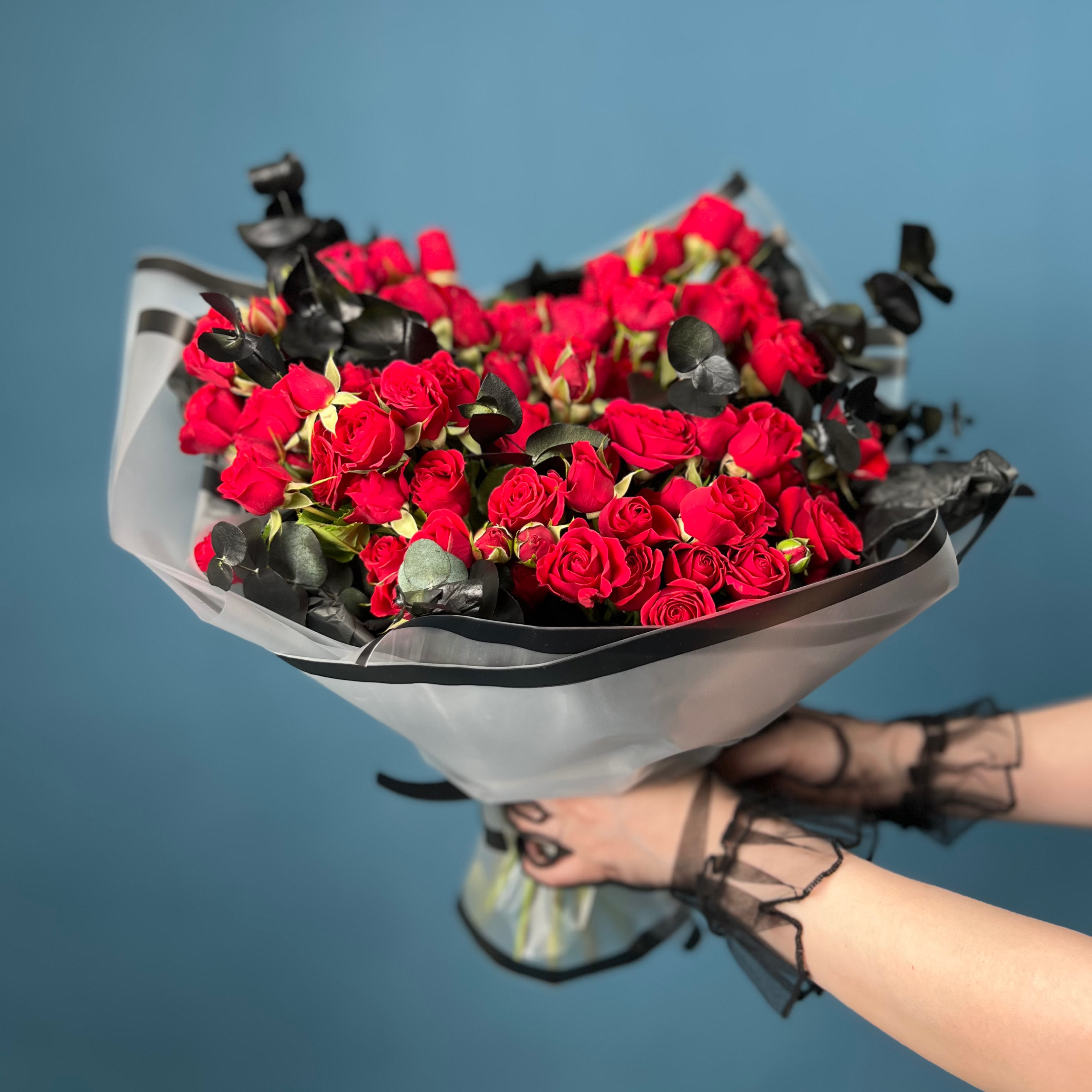 Траурный букет из кустовых красных роз в упаковке