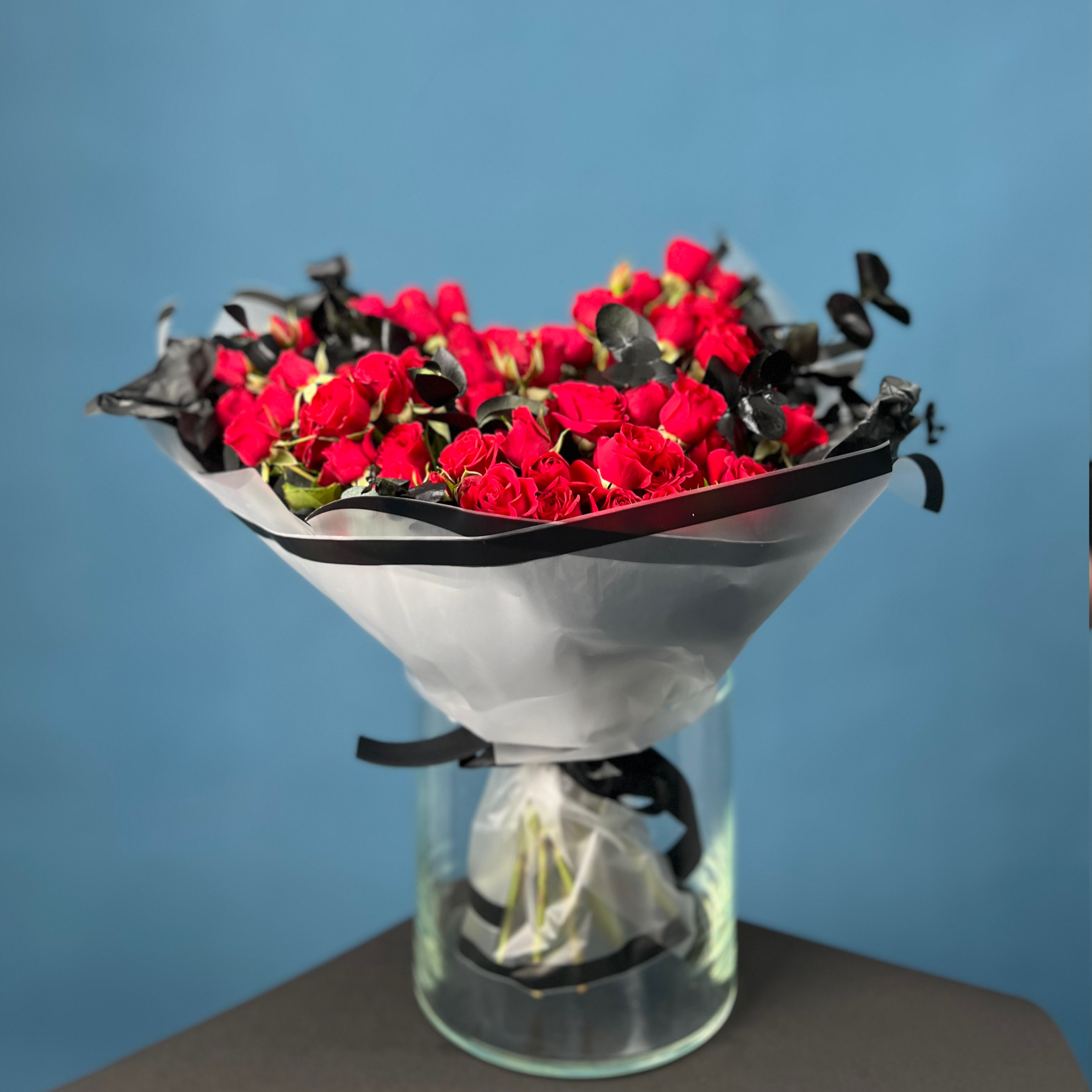 Траурный букет из кустовых красных роз в упаковке