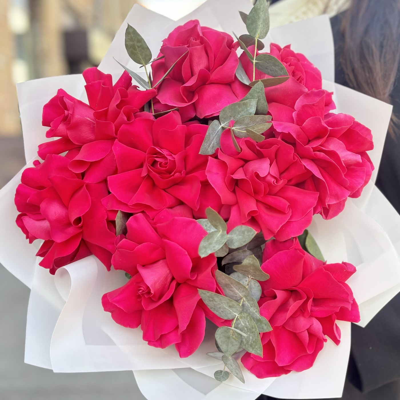 9 пышных малиновых роз с эвкалиптом в упаковке