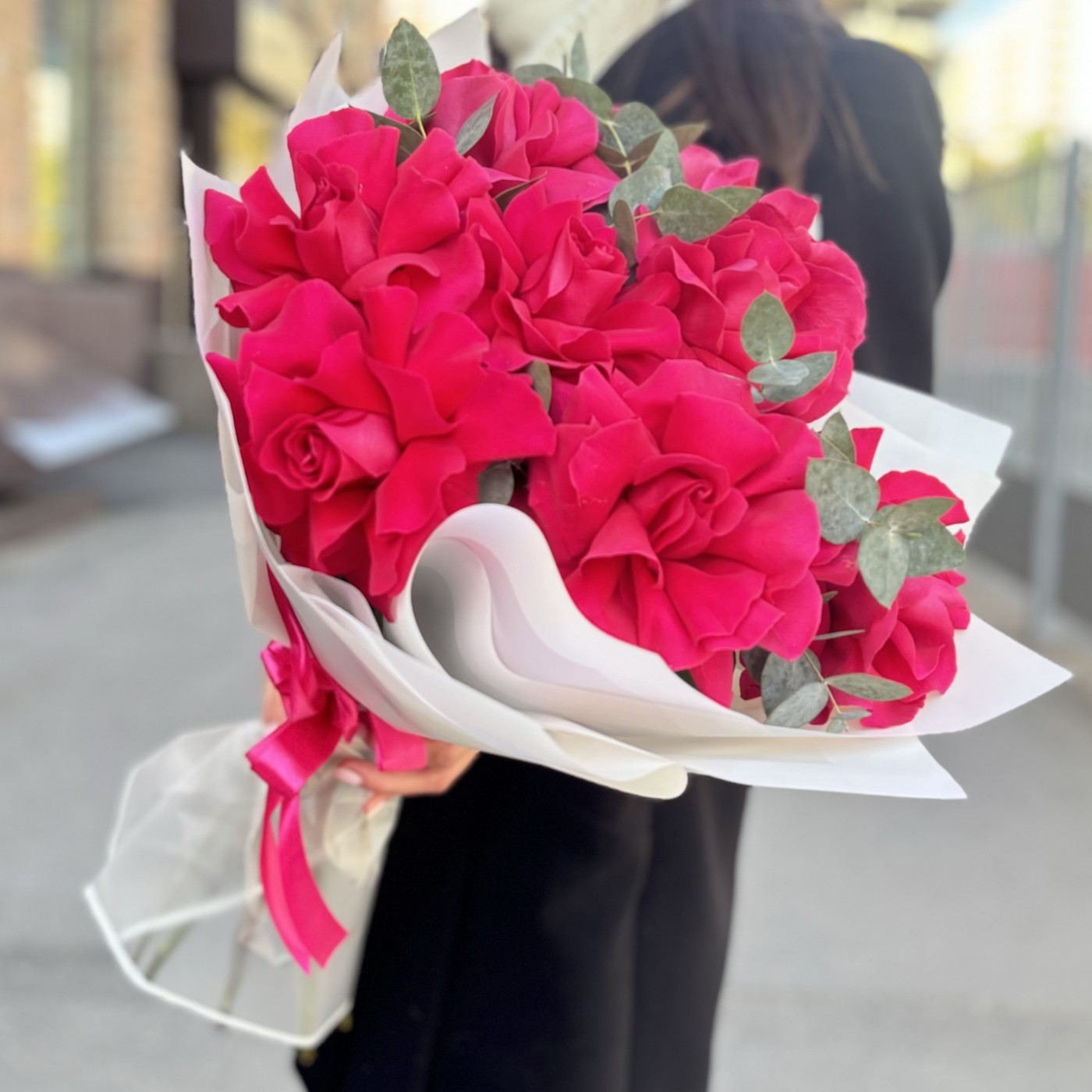 9 пышных малиновых роз с эвкалиптом в упаковке