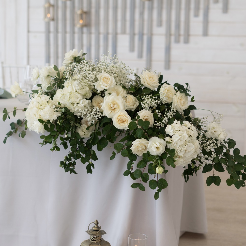 Композиция из белых гортензий и роз на стол молодоженов